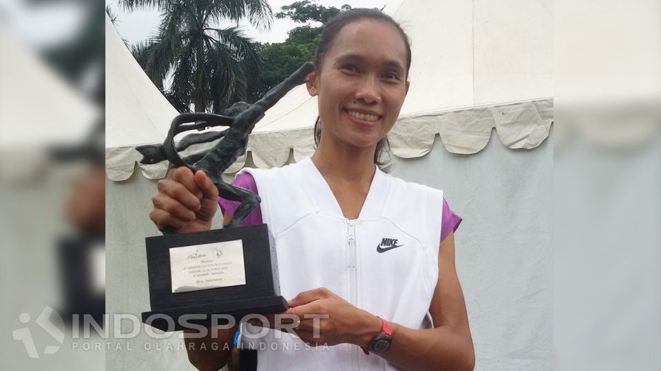 Rini Budiarti saat meraih trofi juara Jakarta Marathon 2016 kategori 10K. Copyright: © Lanjar Wiratri/INDOSPORT